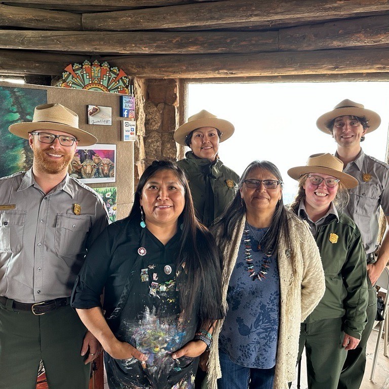 Grand Canyon rangers pose with cultural demonstrator and artist Janet Yazzie
