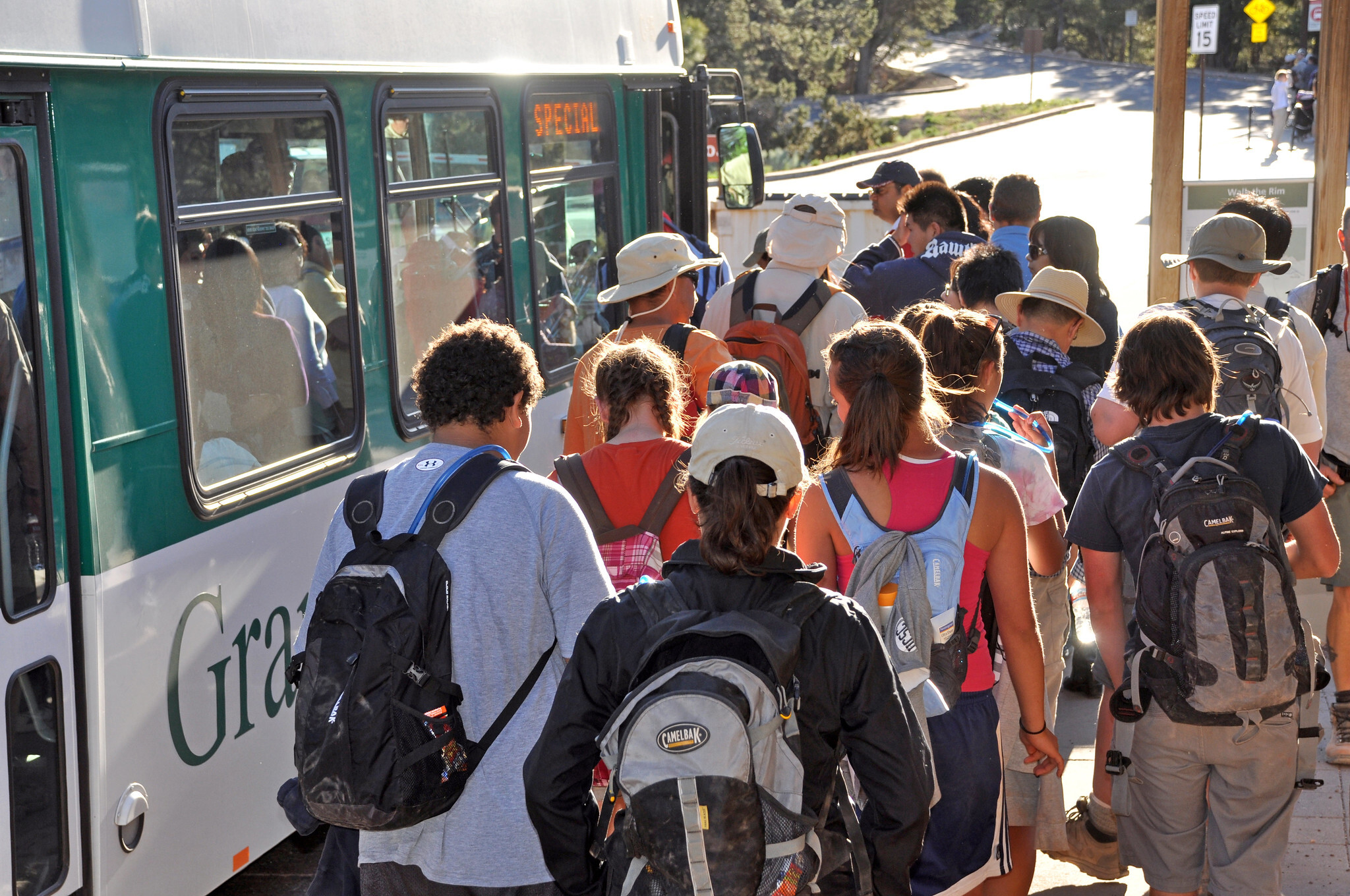 a group of people try to get on a crowded bus at grand canyon