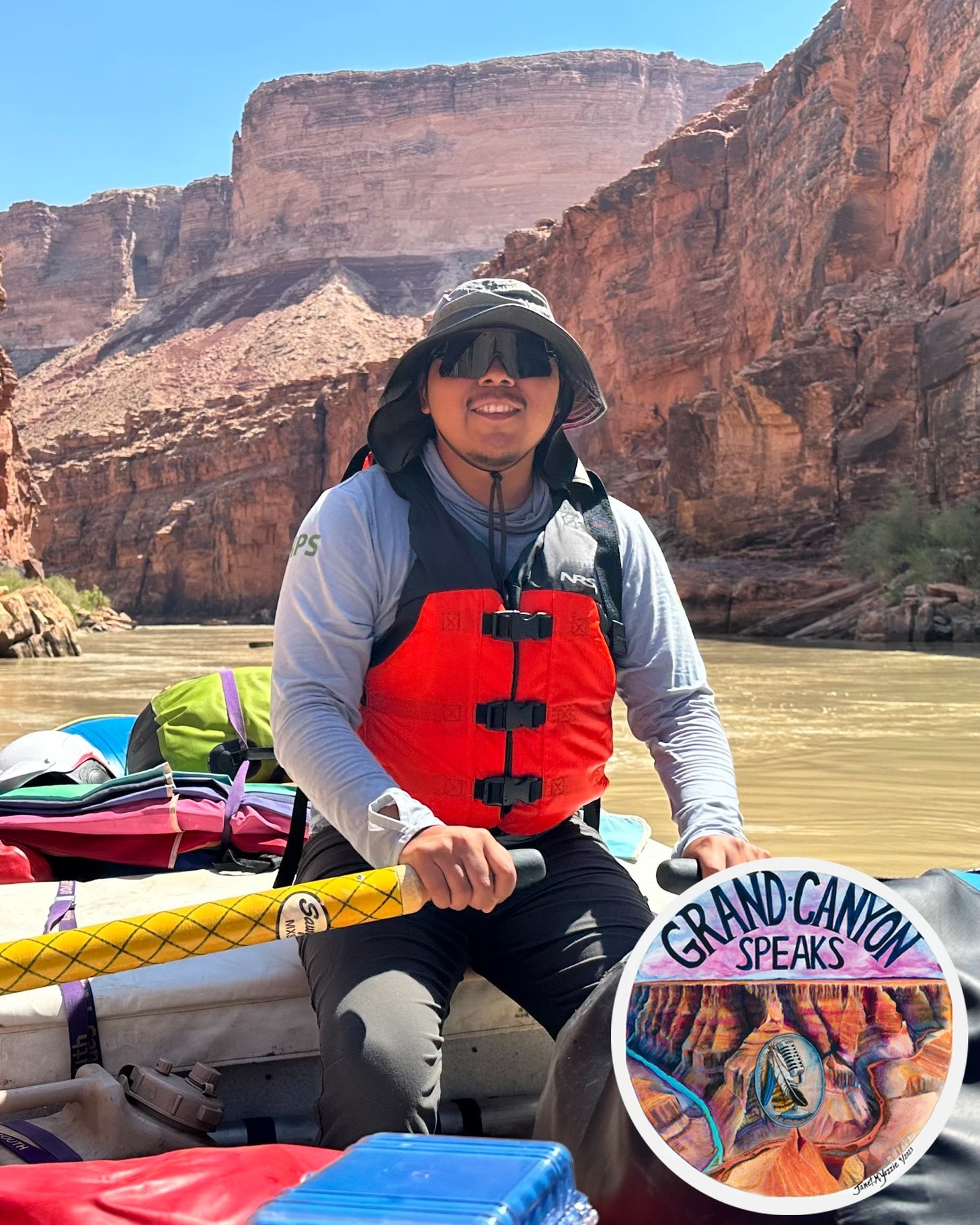 A man with a lifejacket on smiles at the camera on a river trip on the Colorado River