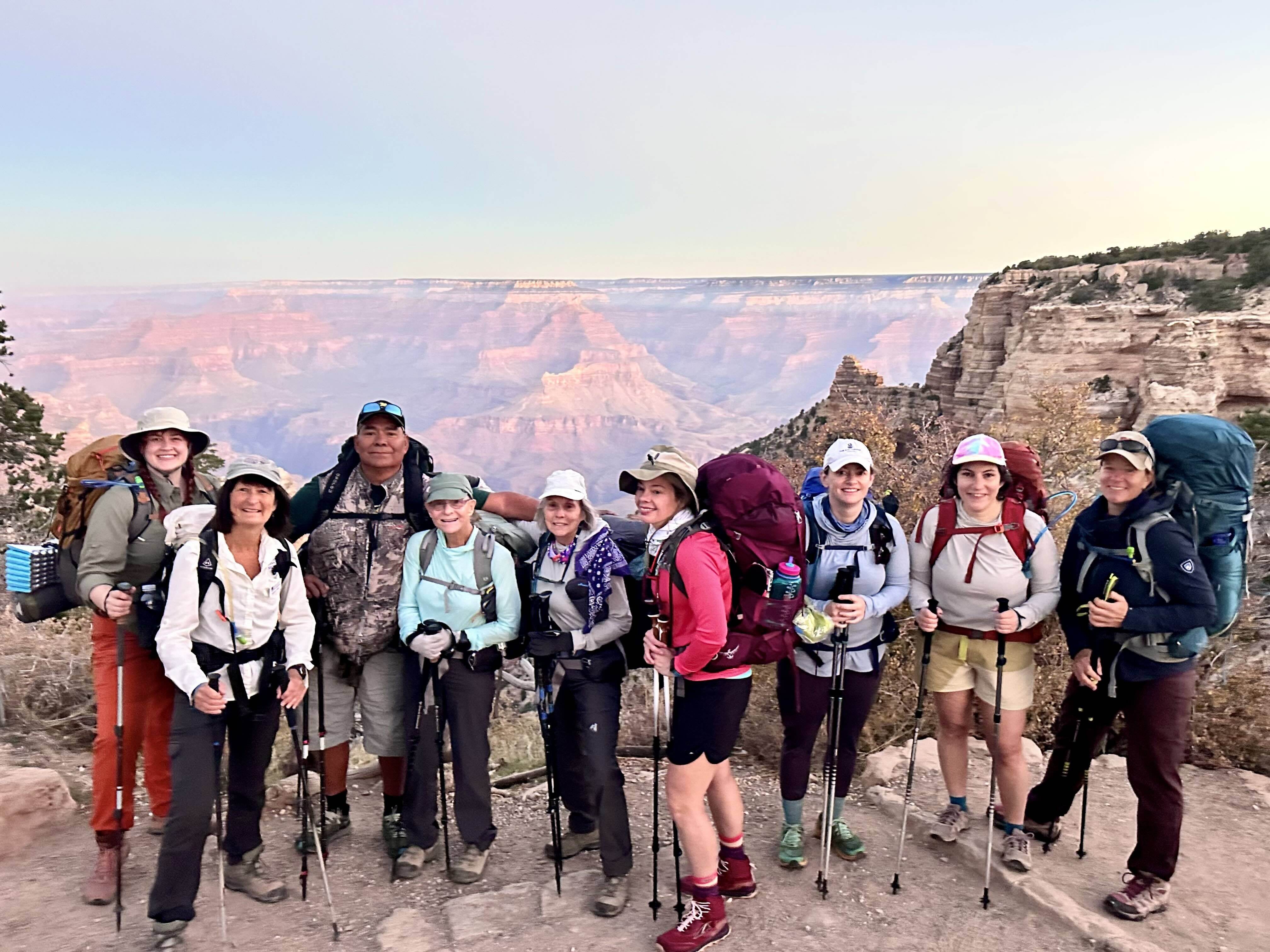 Group of backpackers pose in front of the canyon