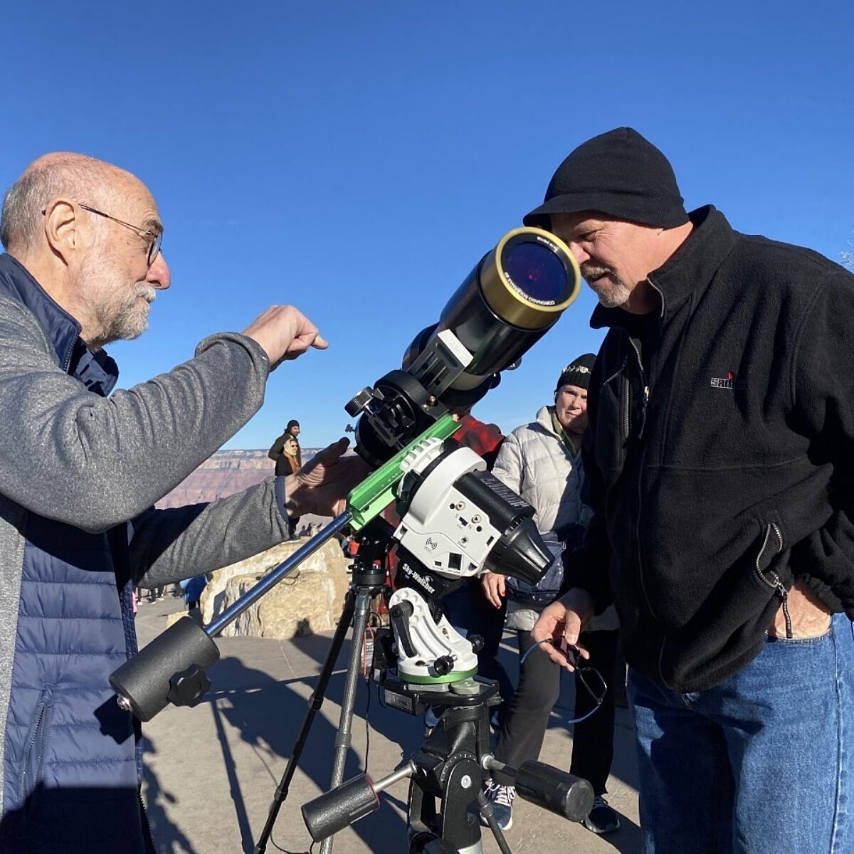 Two men looking at a telescope