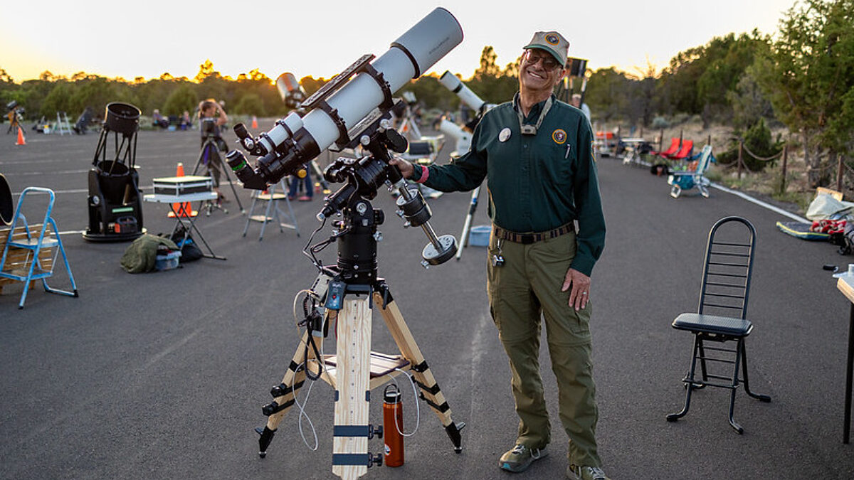 Star Party 2024 Astronomer Volunteer smiles for the camera with his telescope