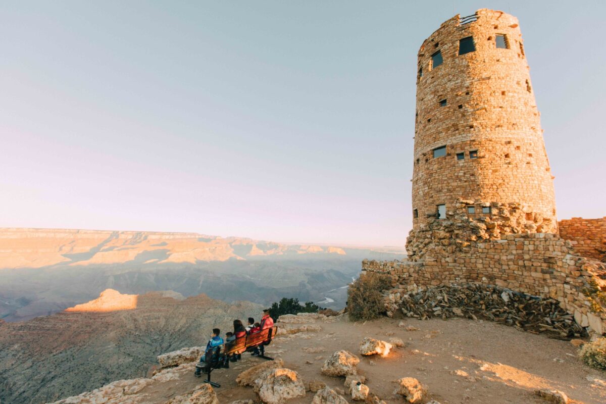 view of family of four on bench in front of the desert view tower
