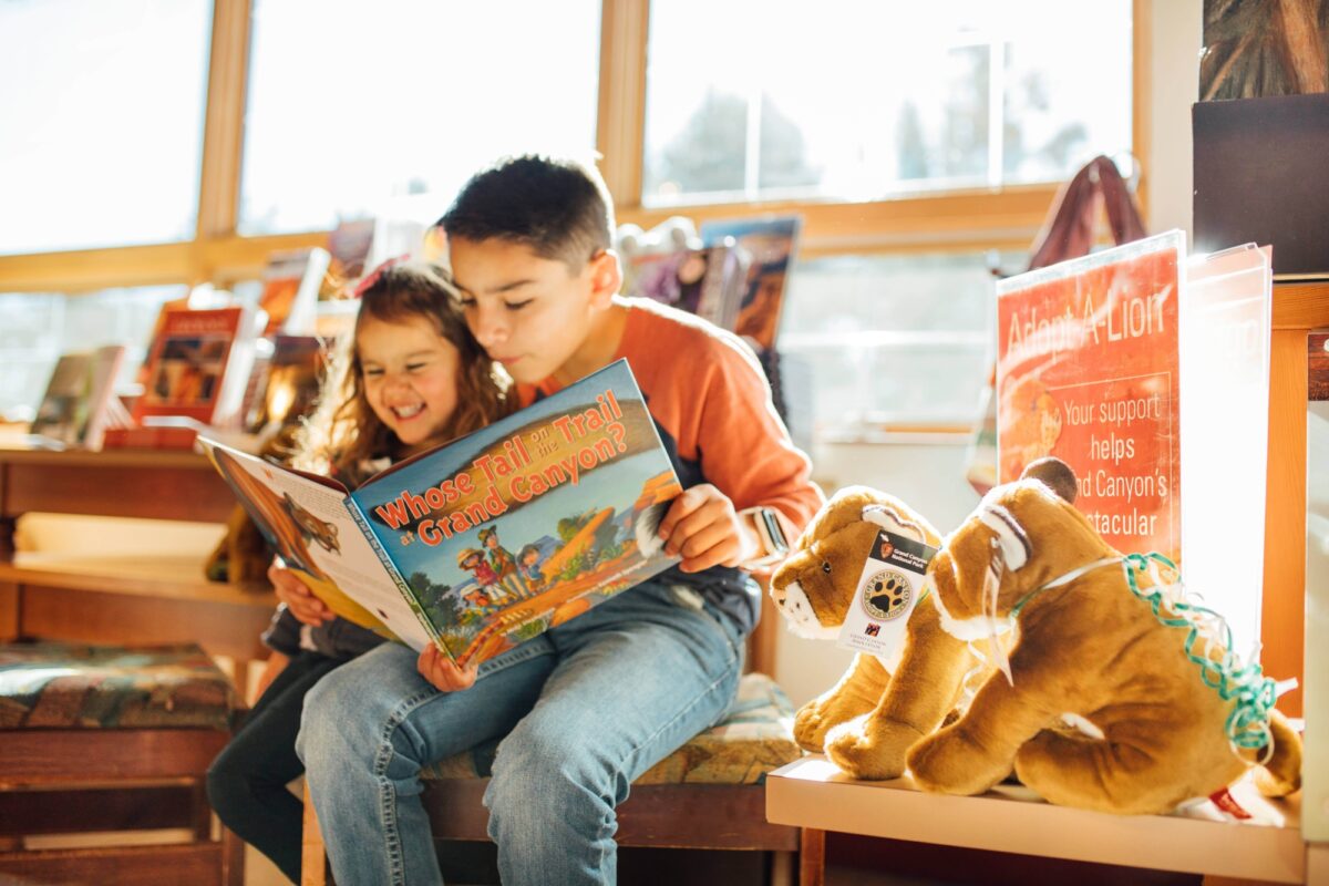 Image of two young children smiling while reading a childrens book about the grand canyon PC Lear Miller