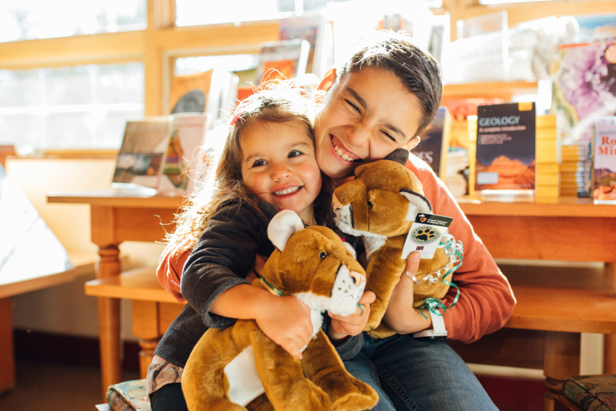 two children at the grand canyon bookstore holding stuffed souvenirs