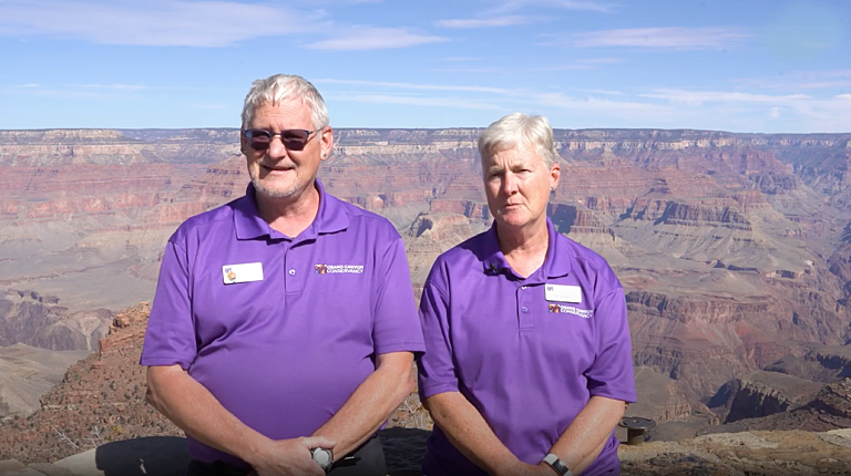 Ann Neubaum and Ed Neubaum, Visitor Experience Specialists, sitting in front of Grand Canyon Visitor Center during interview about seasonal work