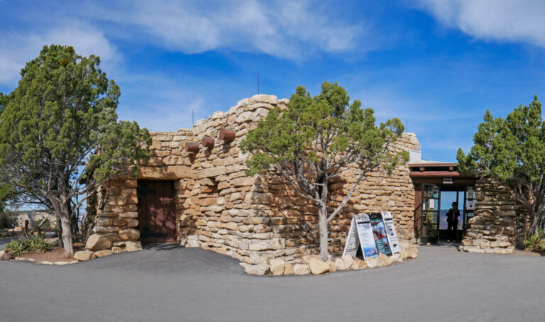 An irregularly-shaped one-story building, approximately 40-feet (12 m) deep by 65-feet (20 m) wide; exterior walls and foundation are made of uniformly-sized limestone boulders.