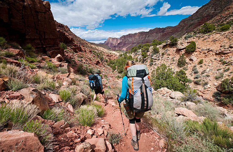Wide angle photo behind two hikers on Tanner Trail, photo by John Strother, 2017
