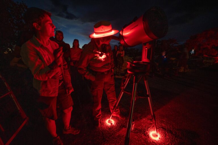 A park ranger gives a dark sky program and shows a visitor an object through a telescope. PC L/Cisneros