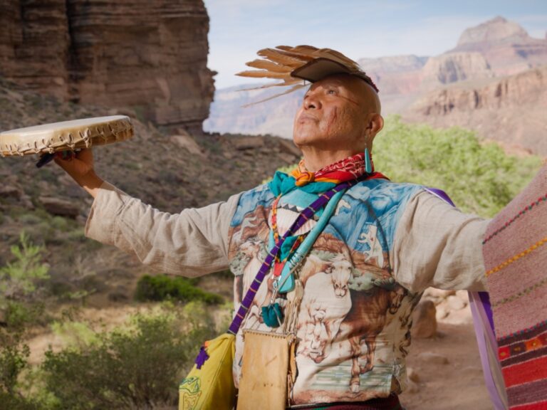 James Uqualla stands with his arms open at Grand Canyon.