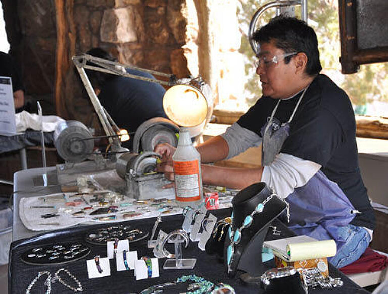 Person making jewelry at work table