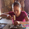 Clinessia Lucas working on jewelry with wooden tools