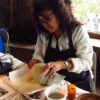Noreen Simplicio working on clay pot on paper towel