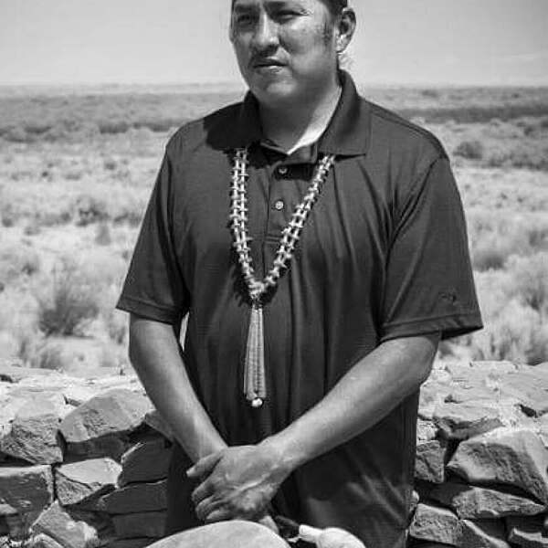 Black and white photo of Delwyn Tawvaya in front of drum