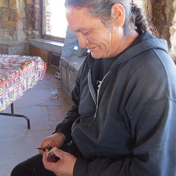 Curtis Naseyowma working with knife to carve wood