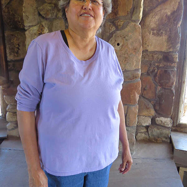 Jayne Quam standing and smiling in stone building