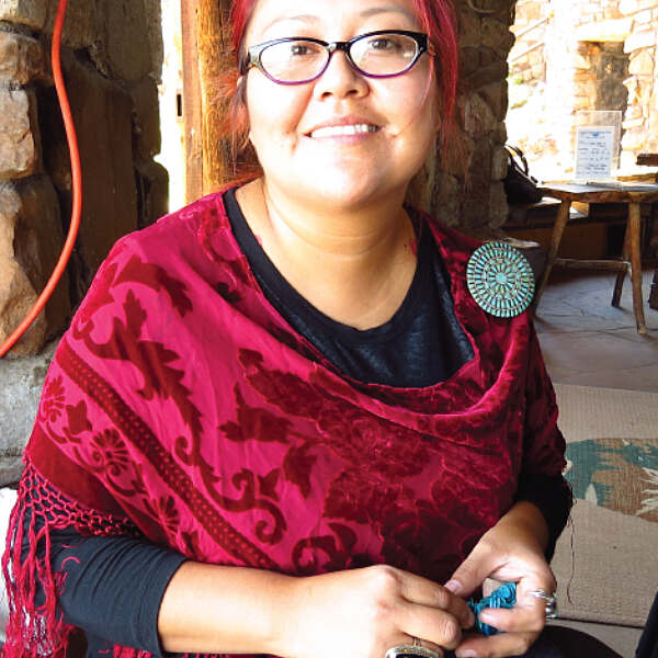 Jerliyn Yazzie smiling while holding jewelry