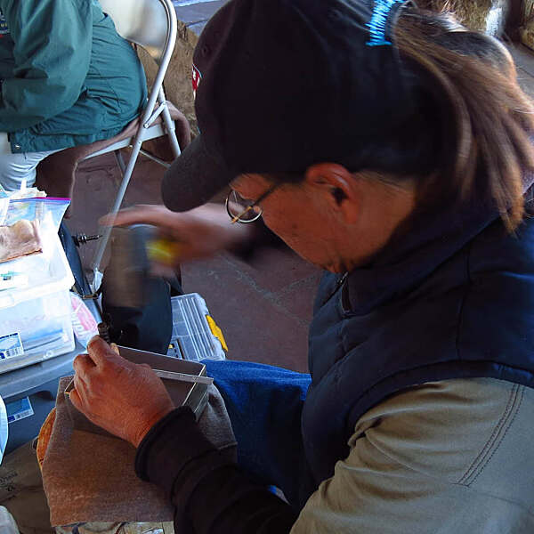 Overhead view of Leo Chee seated working on silver jewelry