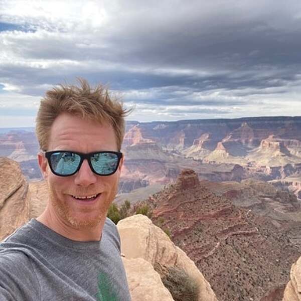 Dr. Cameron takes a selfie with sunglasses on and the Grand Canyon in the background.