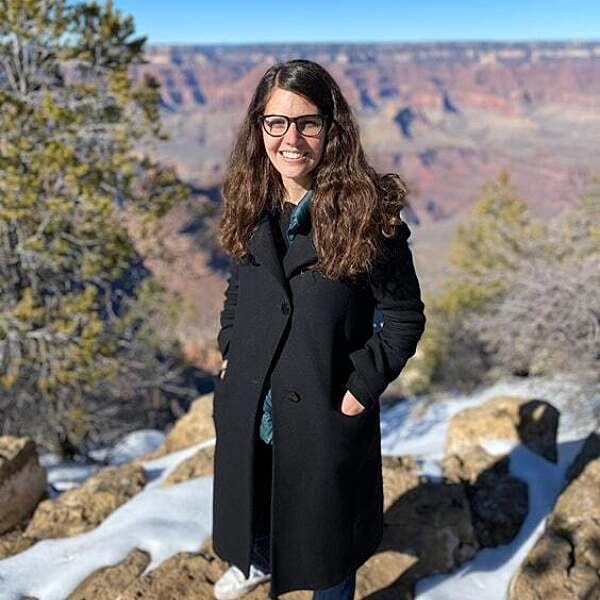 Daniele Genadry stands on snowy ground at the edge of Grand Canyon.