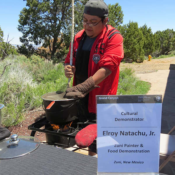 Elroy Natachu Jr. cooking over fire stove