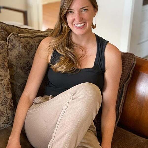 Portrait of Erin Reynolds sitting on a couch.